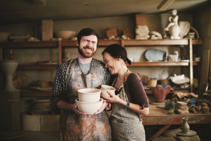 Happy potters family posing in small workshop